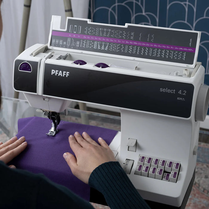 PFAFF sewing machine with a person using it on a purple fabric.
