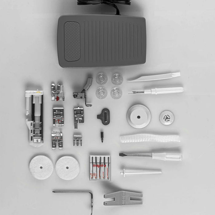 Collection of sewing machine parts and accessories on a gray background