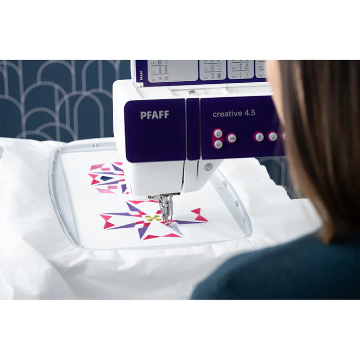 PFAFF embroidery machine with a person operating it, featuring colorful designs on a white fabric.