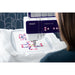 PFAFF embroidery machine with a person operating it, featuring colorful designs on a white fabric.