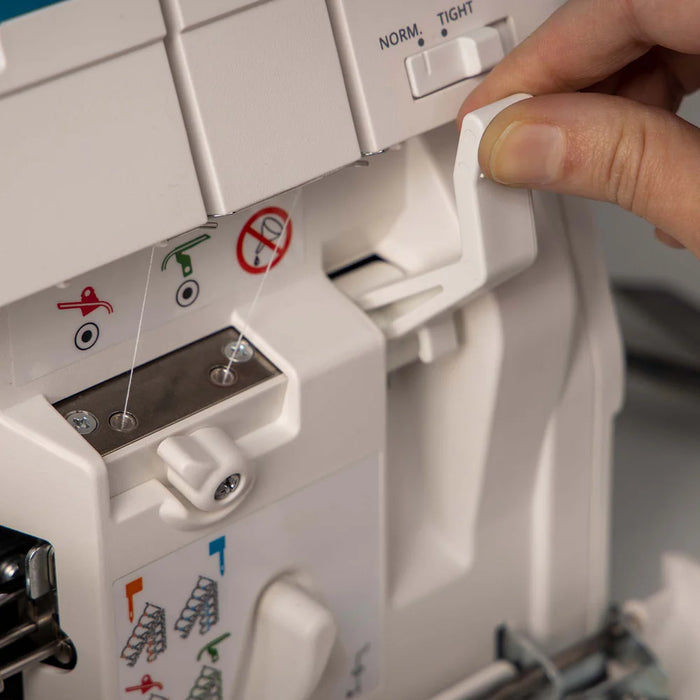 Person adjusting a sewing machine with a close-up of the control panel.