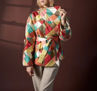 Person wearing a colorful checkered jacket against a dark background
