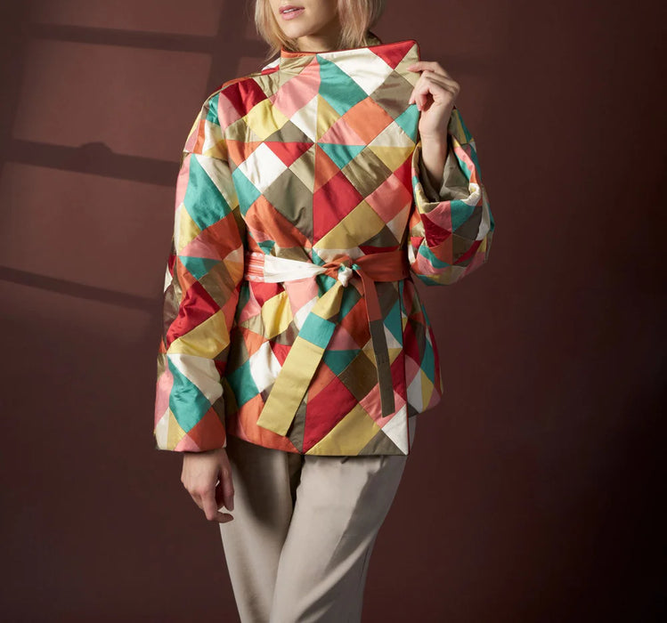 Person wearing a colorful checkered jacket against a dark background