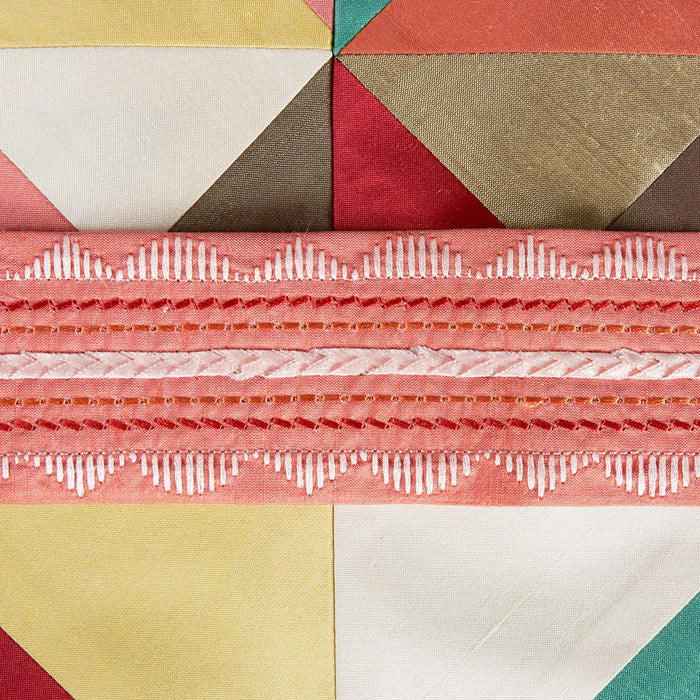 Geometric quilt pattern with colorful triangles and horizontal stripes.