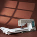 Sewing machine on a brown surface with a window-like shadow pattern