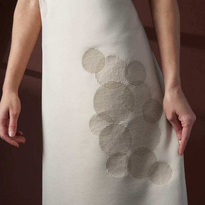 White dress with a textured circular design on a dark background
