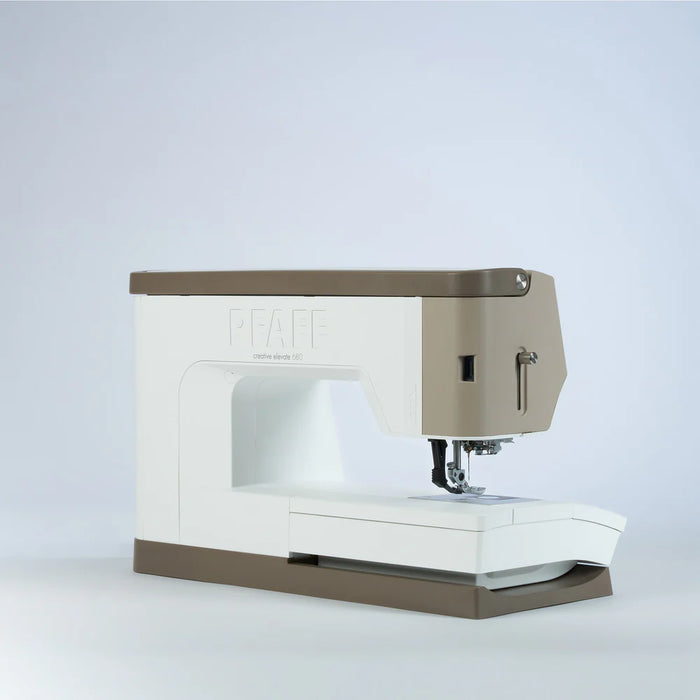 Sewing machine with beige top and white base on a light gray background