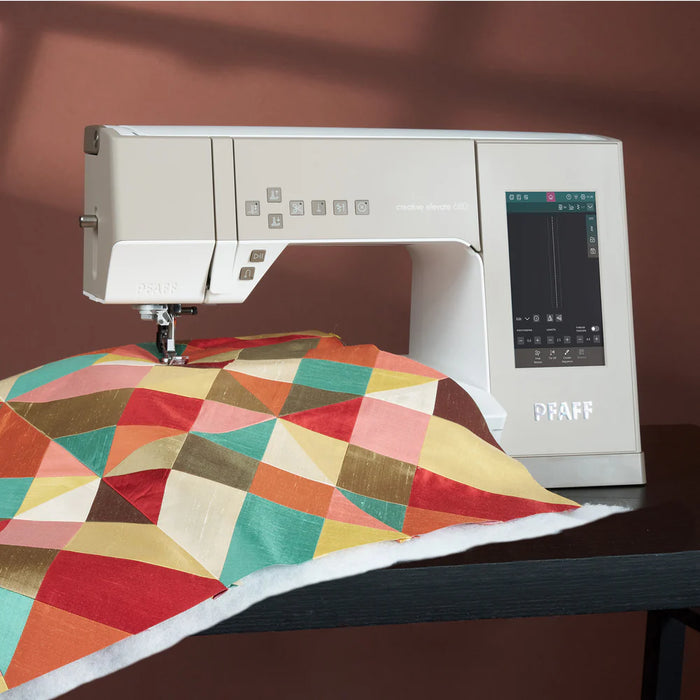 Sewing machine with a colorful quilt on a brown background