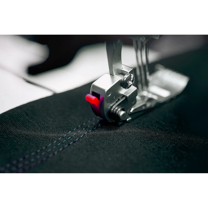 Close-up of a sewing machine needle stitching fabric