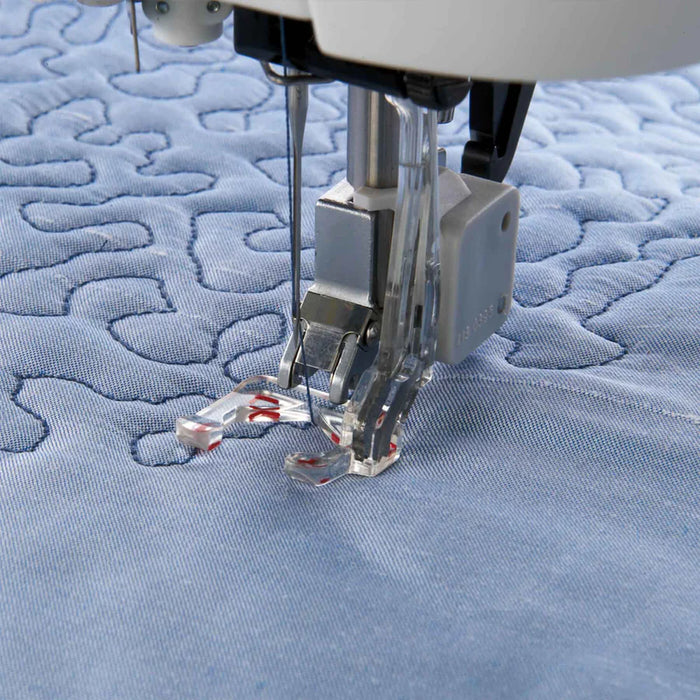 Sewing machine needle on a piece of blue quilted fabric