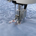 Sewing machine needle on a piece of blue quilted fabric