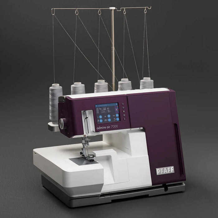 Sewing machine with multiple spools of thread on a dark background