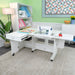 Arrow Christa Sewing Cabinet in White shown with extended quilt leaves and storage drawer open in a creative workspace.