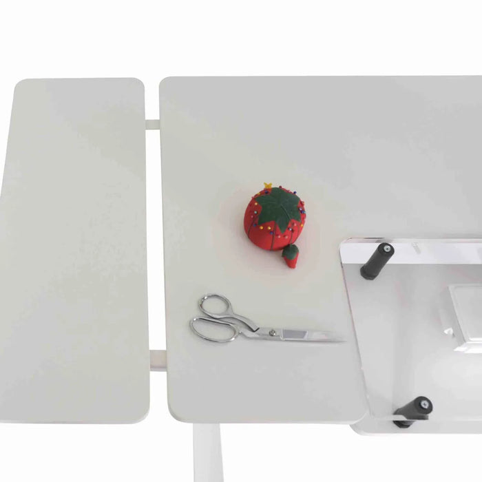 Side extension leaf of Arrow Eleanor 691 sewing table holding pincushion and scissors for crafting tasks.