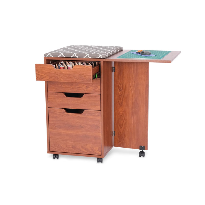 Teak Kangaroo Kiwi Storage Cabinet K7105 with thread drawer open, ironing board on top, and side table extended for sewing tasks.