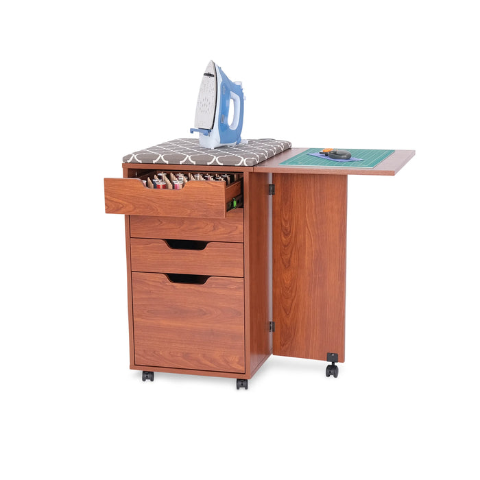 Kangaroo Kiwi Teak Storage Cabinet K7105 with iron resting on ironing board, open thread drawer, and cutting mat on extended table.