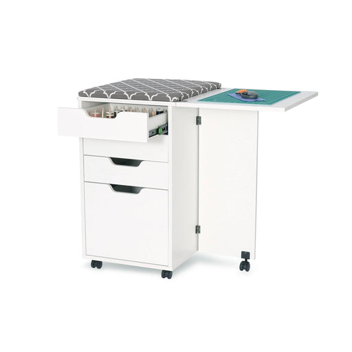Kiwi Sewing Storage Cabinet by Arrow Sewing shown with open drawers displaying thread and tool organization, fold-out cutting table, and gray woodgrain finish on wheels.