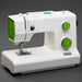 White sewing machine with green accents on a dark background