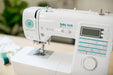 Baby Lock Jubilant BL80B Sewing Machine close-up on controls and stitching interface on a sewing table.