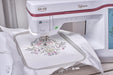 Close-up of Baby Lock BLRT Reflection embroidery machine stitching an intricate floral pattern using its extra-large embroidery area.