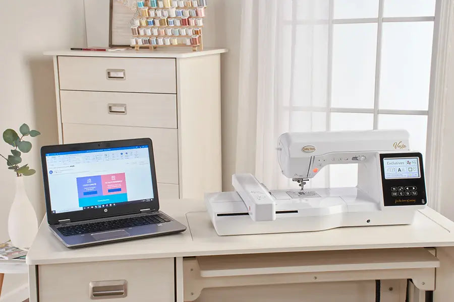Baby Lock BLMVE Vesta connected to laptop for Wi-Fi embroidery design transfer in sewing workspace