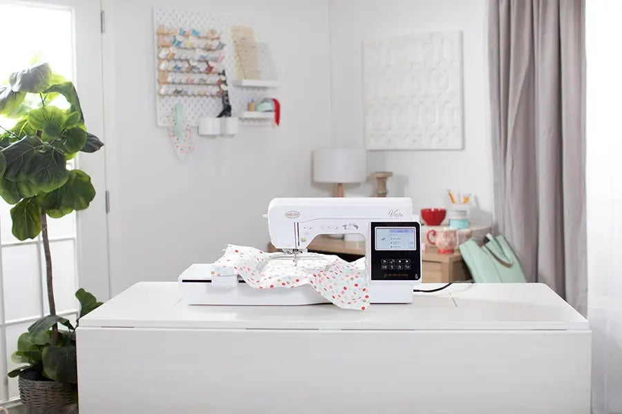 Baby Lock Vesta embroidery machine set up in craft room stitching colorful fabric on embroidery hoop