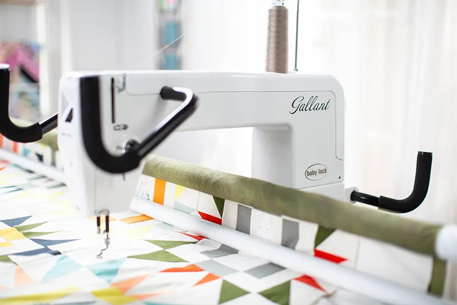 Close-up of Baby Lock Gallant BLGT15 quilting machine stitching geometric quilt pattern on long arm frame.