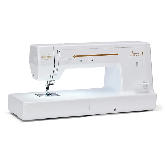 Baby Lock Jazz II sewing machine quilting a colorful patchwork quilt with extended workspace for large projects.
