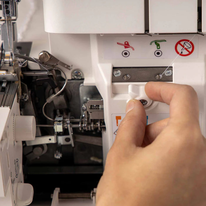 Hand operating a sewing machine with close-up details