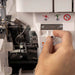 Hand operating a sewing machine with close-up details