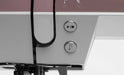Close-up of a sewing machine with control buttons on a white background
