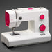White sewing machine with pink accents on a gray background