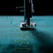 Sewing machine needle stitching on teal fabric