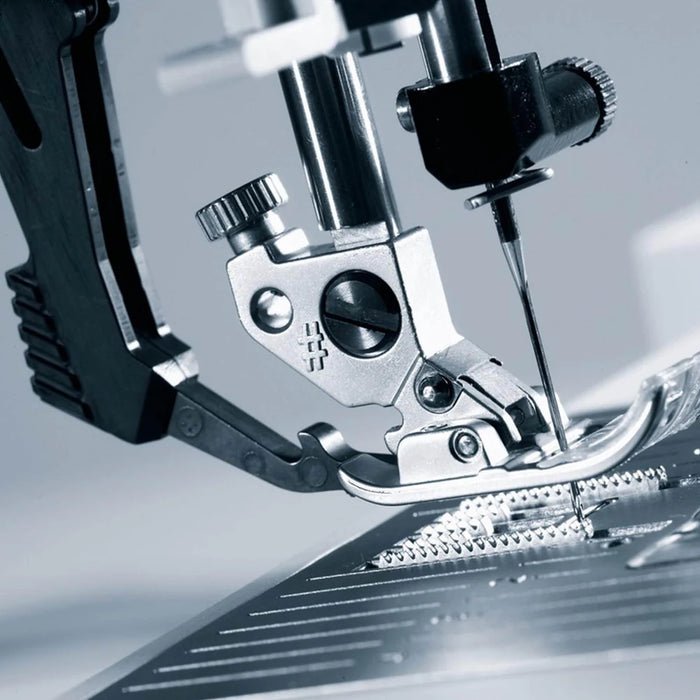 Close-up of a sewing machine needle and presser foot on a blurred background