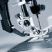 Close-up of a sewing machine needle and presser foot on a blurred background