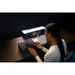 Woman using a sewing machine with a dark background