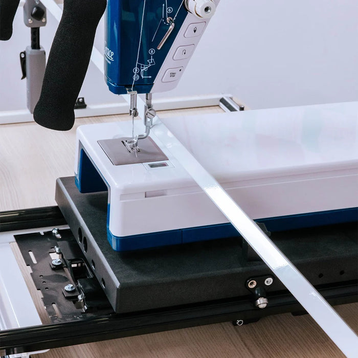 Close-up of quilting machine needle and base mounted on Grace Cutie Breeze rolling carriage system