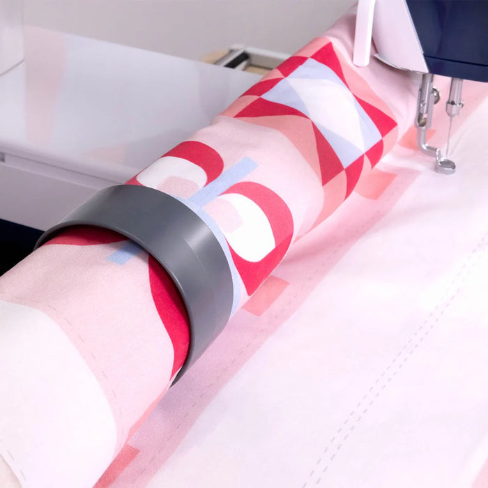 Close-up of quilt fabric secured on Grace Cutie Breeze frame rollers during free-motion quilting