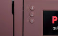Close-up of a pink kitchen appliance with control buttons and a screen.