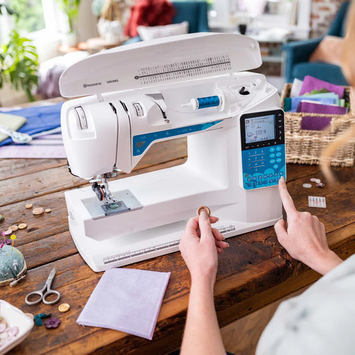 Husqvarna Viking Opal 650 sewing machine in use on wooden table showing user selecting stitches on digital control panel