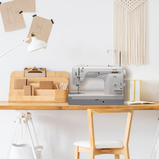 Janome 1600P-QC sewing machine displayed in a modern home sewing studio, high-speed straight stitch machine for quilting and dressmaking.