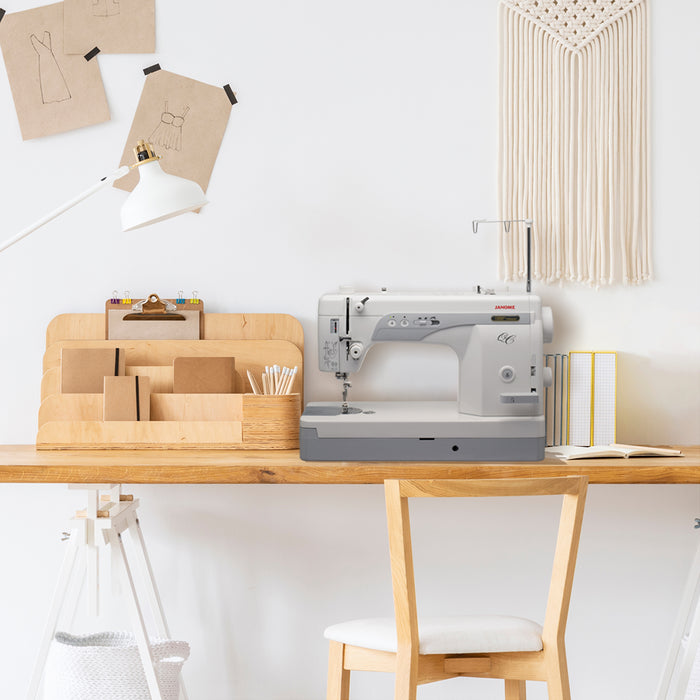 Janome 1600P-QC sewing machine displayed in a modern home sewing studio, high-speed straight stitch machine for quilting and dressmaking.