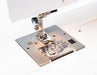 Detailed view of Janome Sewist 725S presser foot and needle plate highlighting feed dogs and easy-access bobbin.
