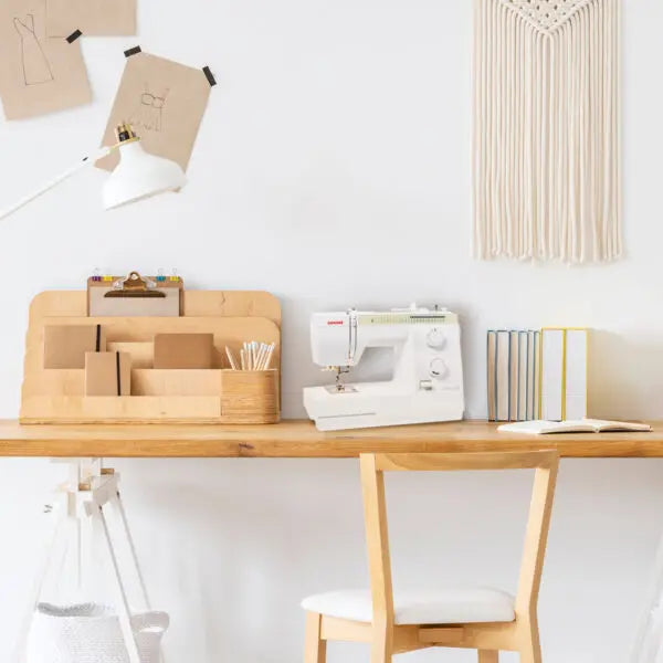Janome Sewist 725S sewing machine displayed in a modern craft room workspace setup.
