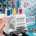 Janome MB-7 multi-needle embroidery machine in sewing studio with thread spools, professional seven-needle embroidery setup for high-detail stitching and small business production.