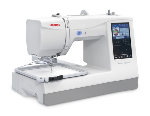 Janome Memory Craft 100E embroidery machine angled view with attached embroidery hoop and full-color LCD screen for design selection.