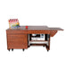 Electric lift sewing cabinet with machine lowered inside cabinet and storage drawers in teak wood