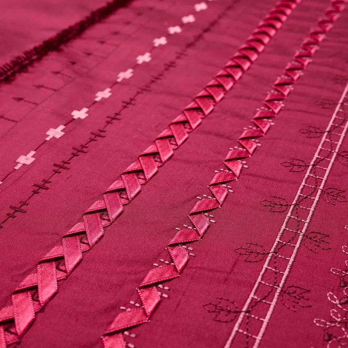 Close-up of a red fabric with intricate patterns and embroidery.