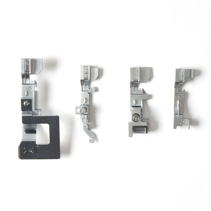 Set of four metal sewing machine presser feet on a white background