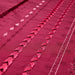 Close-up of a red fabric with intricate patterns and embroidery.